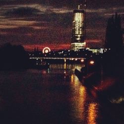 Digital composite image of illuminated buildings and river at night