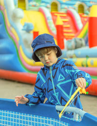 Boy is fishing in the paddling pool. leisure activity. playing kid.