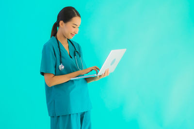 Woman standing against blue background