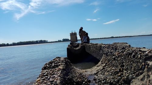 Man in sea against sky