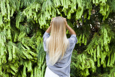Rear view of woman standing against plants