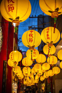 Low angle view of illuminated lanterns hanging at night