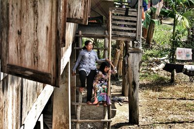 Boy sitting on stairs against built structure