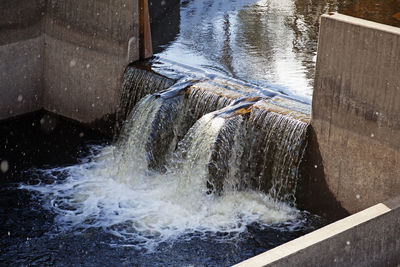 Artificial waterfall at hydropower plant when it snows