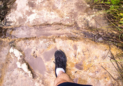 Low section of person standing on rock