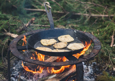 Cooking blini, blin or blynai, pancakes traditional sweet food, preparing outdoor on an open fire