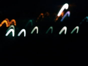 Close-up of illuminated lamp over black background