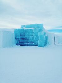 Built structure on snow covered land against sky