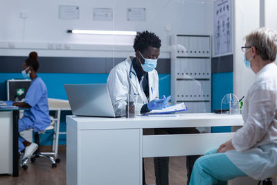 Doctor talking with senior woman at clinic