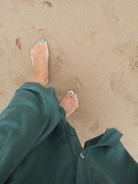 Low section of man standing on beach