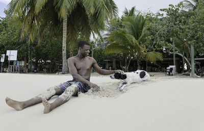 Side view of woman sitting on beach