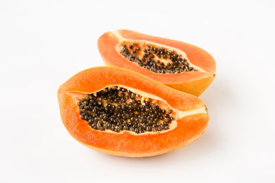 Close-up of orange slice over white background