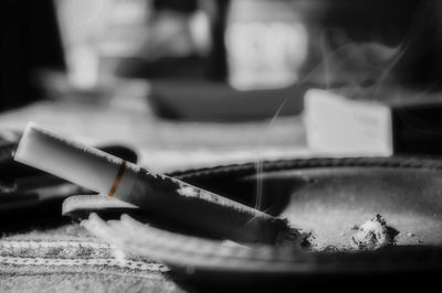 Close-up of cigarette smoking on table