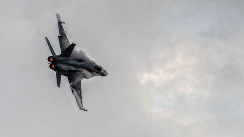 Low angle view of airplane flying against sky