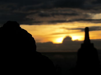 Silhouette man against dramatic sky during sunset