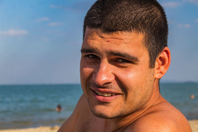 Portrait of mid adult man at beach against sky