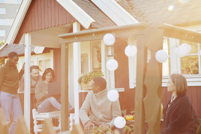 Group of friends with laptop in front of wooden house