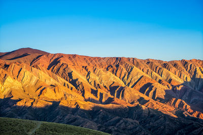 Scenic view of rocky mountains against blue sky