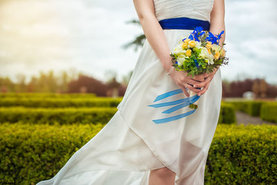 Midsection of woman holding flower bouquet