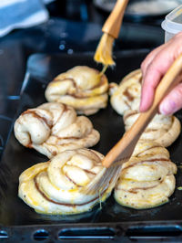 Close-up of person preparing food on barbecue grill
