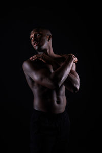 Low angle view of man with arms raised against black background