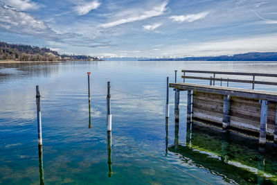 Scenic view of pier at lake against sky