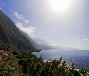 Scenic view of mountains by sea against sky 