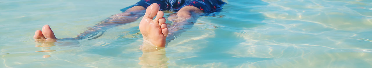 Low section of woman swimming in pool