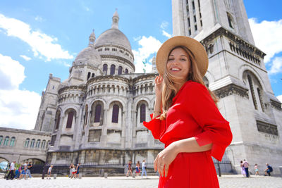 Fashion model walking in paris with the basilica of the sacred heart of paris on the background. 
