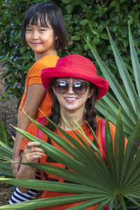Portrait of smiling girl with mother amidst plants