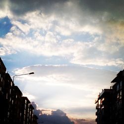 Low angle view of buildings against cloudy sky