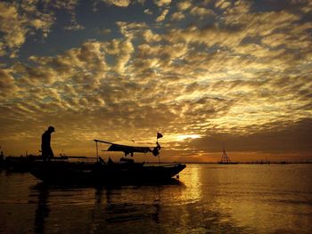 Silhouette boat on sea during sunset