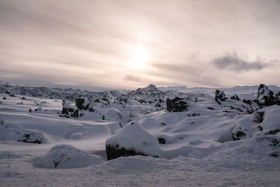 Scenic view of snowcapped landscape against sky during sunset