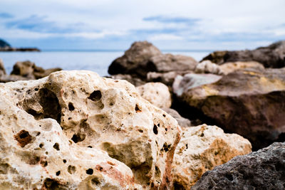 Close-up of rocks on beach against sky