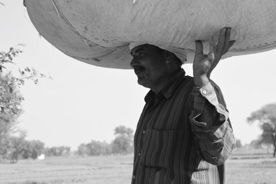 Man with arms outstretched standing on field