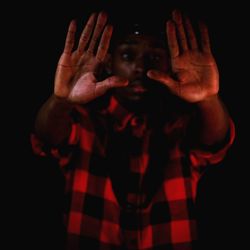 Portrait of human hand against black background