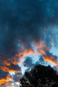 Low angle view of tree against cloudy sky