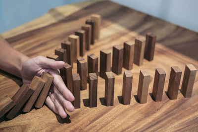 Cropped hand of woman amidst dominoes on table