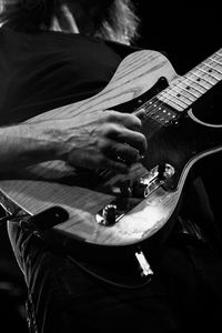 Midsection of musician playing guitar