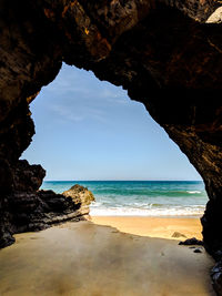 Rock formation on beach against sky