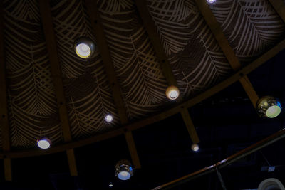 Low angle view of illuminated pendant lights hanging from ceiling