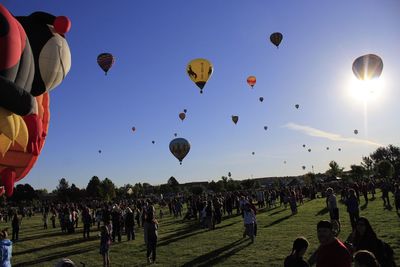 Group of people in hot air balloons against sky