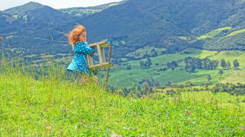 Woman sitting on grass in field