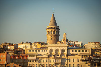 Buildings in city against clear sky