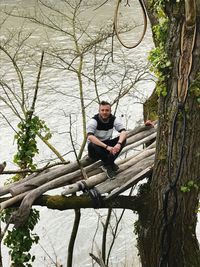 High angle view of a man sitting on tree