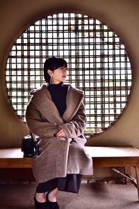 Woman sitting on seat at japanese garden 