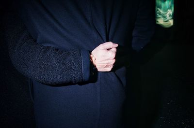 Close-up of man with hand on black background