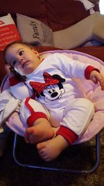 Boy playing with baby sitting on bed