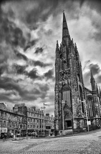 Low angle view of tower against cloudy sky