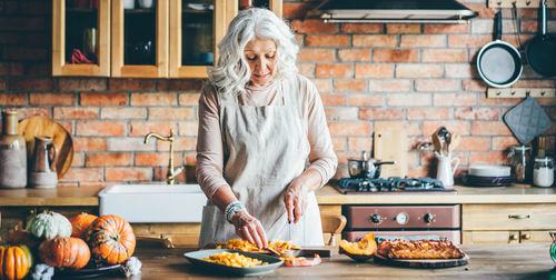 Portrait of young woman preparing food at home